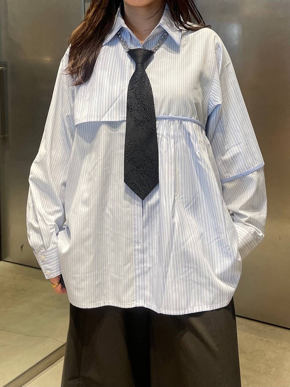 ブラック系のネクタイ、ブラック系のブーツ、ブルー系のシャツ/ブラウスを着用したレディースの春コーディネートの4枚目の写真