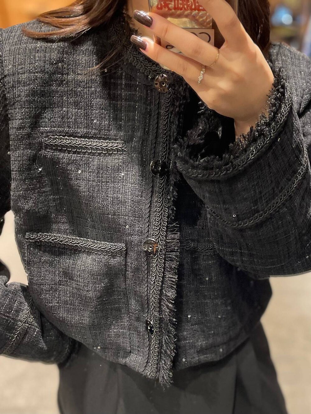 ブラック系のノーカラージャケット、ブラック系のスラックスを着用したレディースの秋コーディネートの3枚目の写真