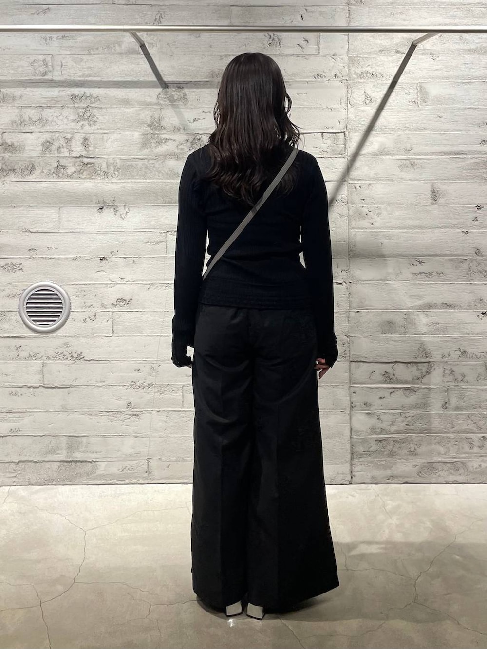 ブラック系のブーツ、グレー系のショルダーバッグ、ブラック系のニット/セーターを着用したレディースの冬コーディネートの3枚目の写真