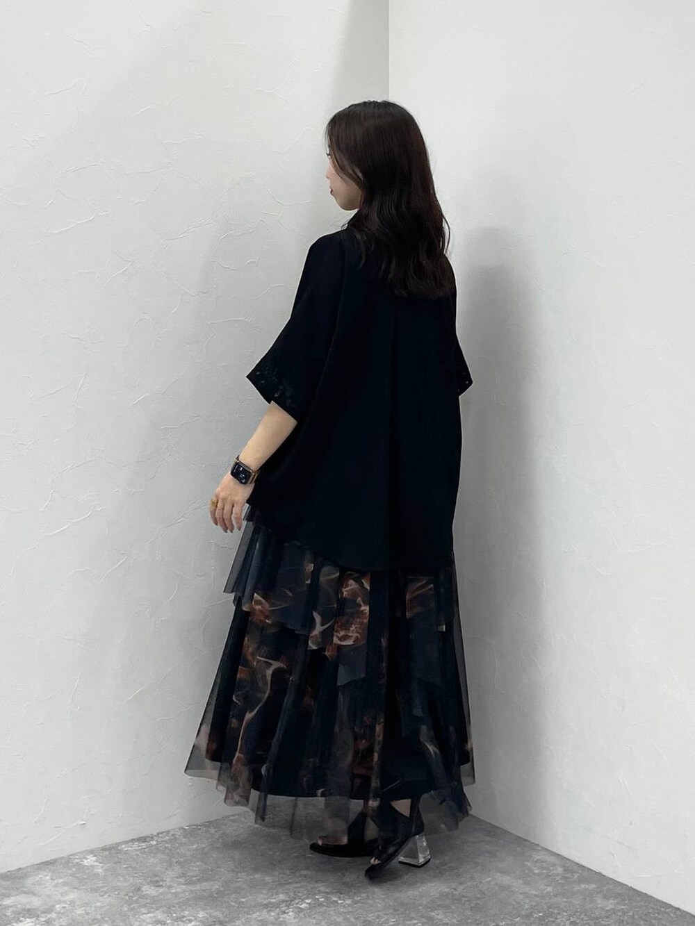 ブラック系のサンダル、ブラック系のショルダーバッグ、オレンジ系のスカートを着用したレディースの夏コーディネートの2枚目の写真