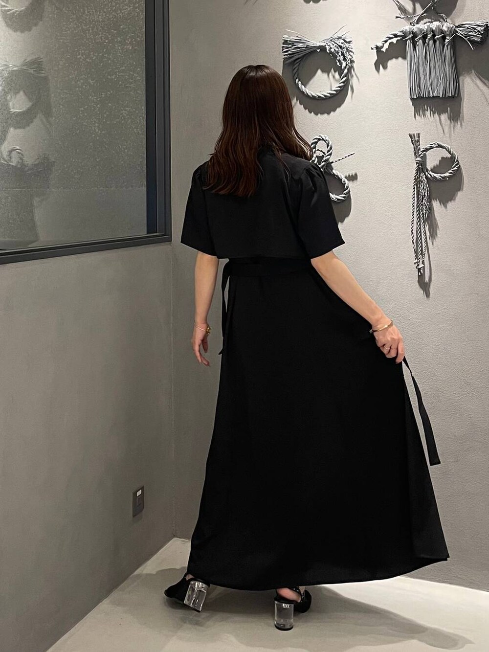 ブラック系のサンダル、ブラック系のワンピースを着用したレディースの夏コーディネートの2枚目の写真