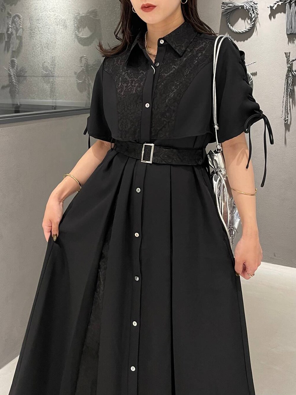 ブラック系のサンダル、ブラック系のワンピース、シルバー系のショルダーバッグを着用したレディースの夏コーディネートの4枚目の写真