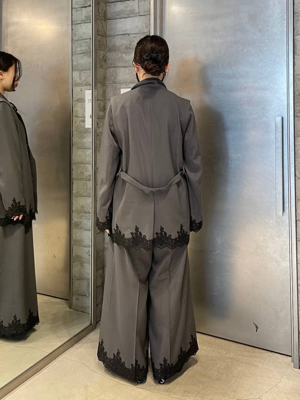 ブラック系のパンプス、グレー系のスラックス、グレー系のテーラードジャケットを着用したレディースの冬コーディネートの3枚目の写真