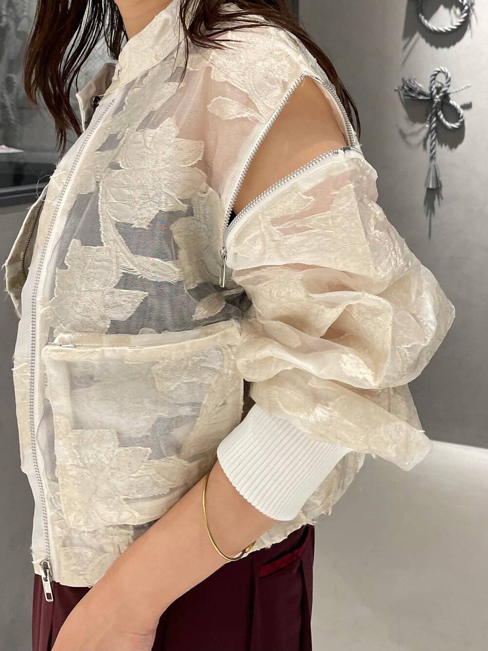 ブラック系のタンクトップ、ブラック系のパンプス、ホワイト系のブルゾンを着用したレディースの夏コーディネートの5枚目の写真