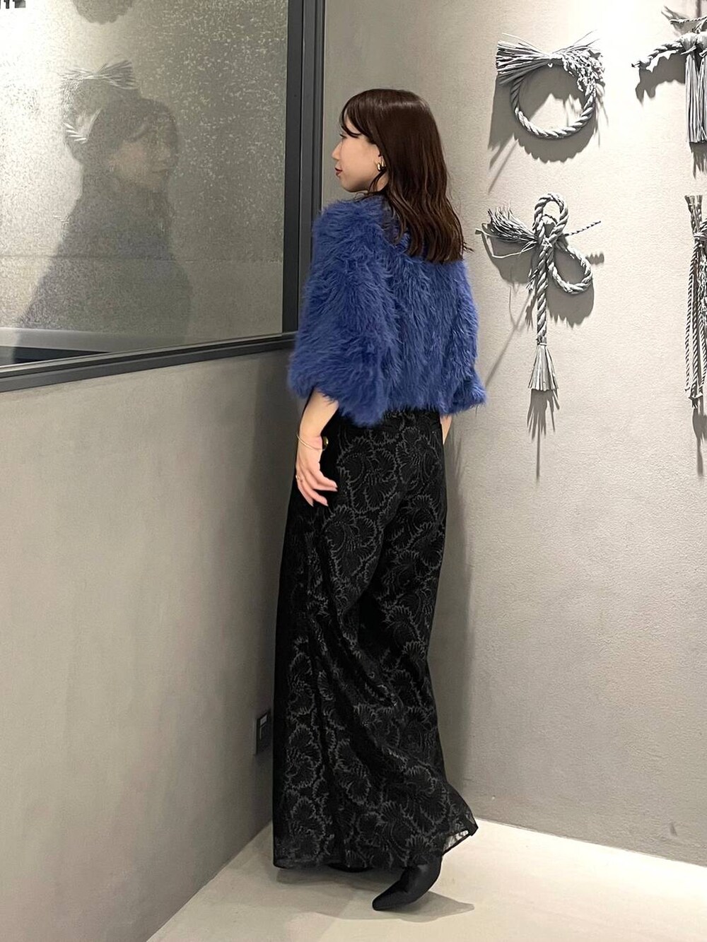 ブルー系のニット/セーター、ブラック系のブーツ、ブラック系のその他パンツを着用したレディースの秋コーディネートの2枚目の写真