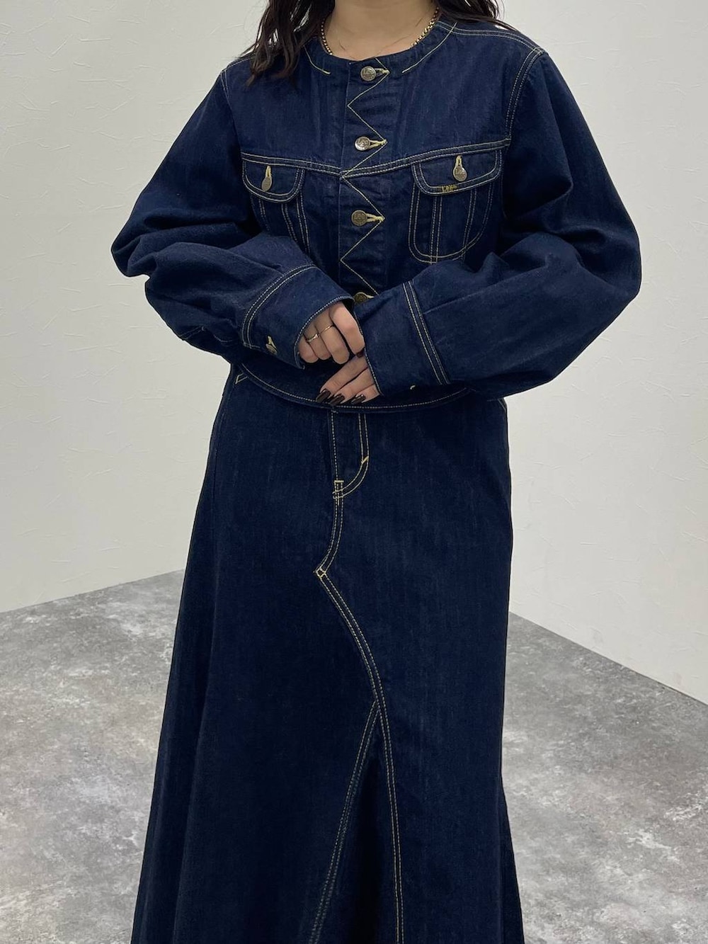 ブルー系のデニムジャケット、ブラック系のブーツ、ブルー系のデニムスカートを着用したレディースの秋コーディネートの5枚目の写真