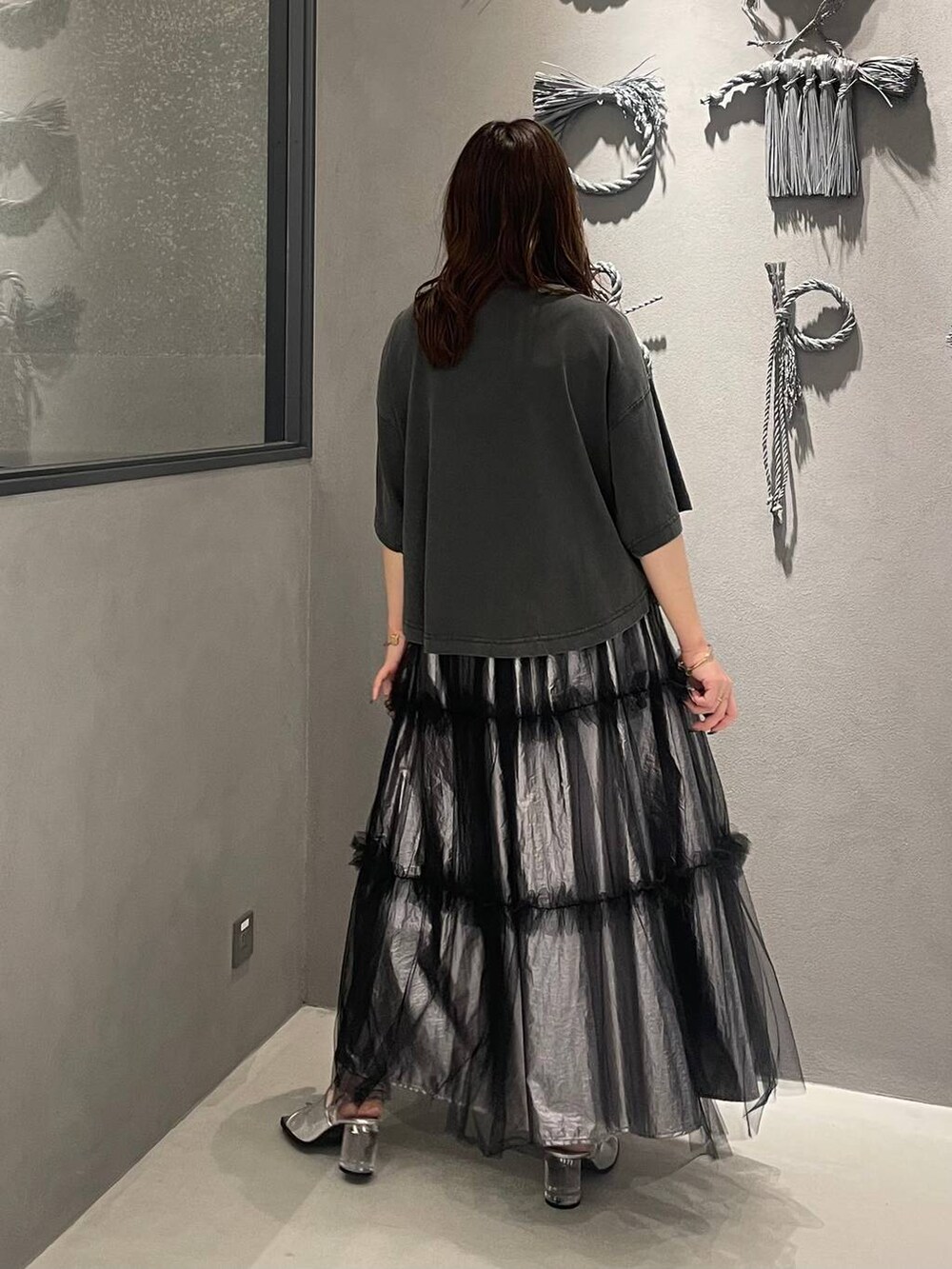 シルバー系のサンダル、シルバー系のスカート、ブラック系のTシャツ/カットソーを着用したレディースの春コーディネートの3枚目の写真