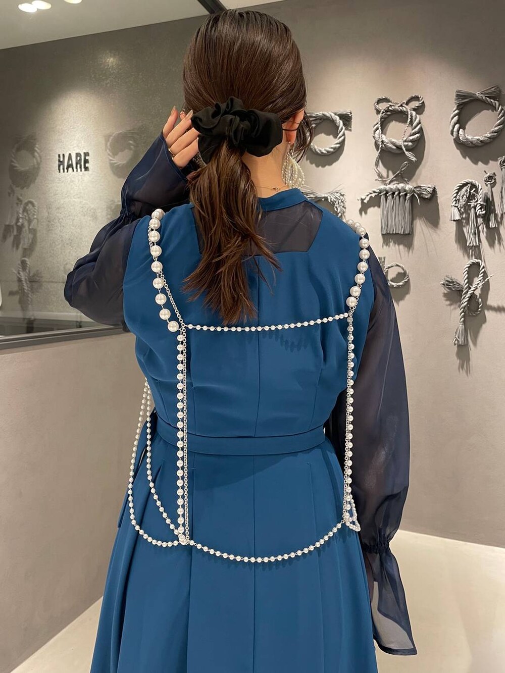 ブラック系のパンプス、ブラック系のショルダーバッグ、ホワイト系のサスペンダーを着用したレディースの秋コーディネートの5枚目の写真