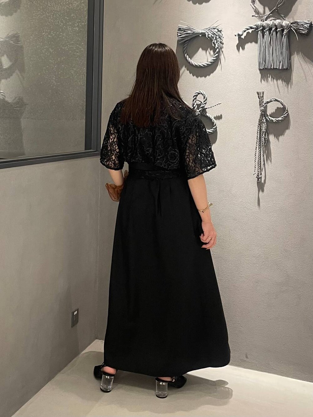 ブラック系のサンダル、ブラック系のワンピースを着用したレディースの夏コーディネートの2枚目の写真