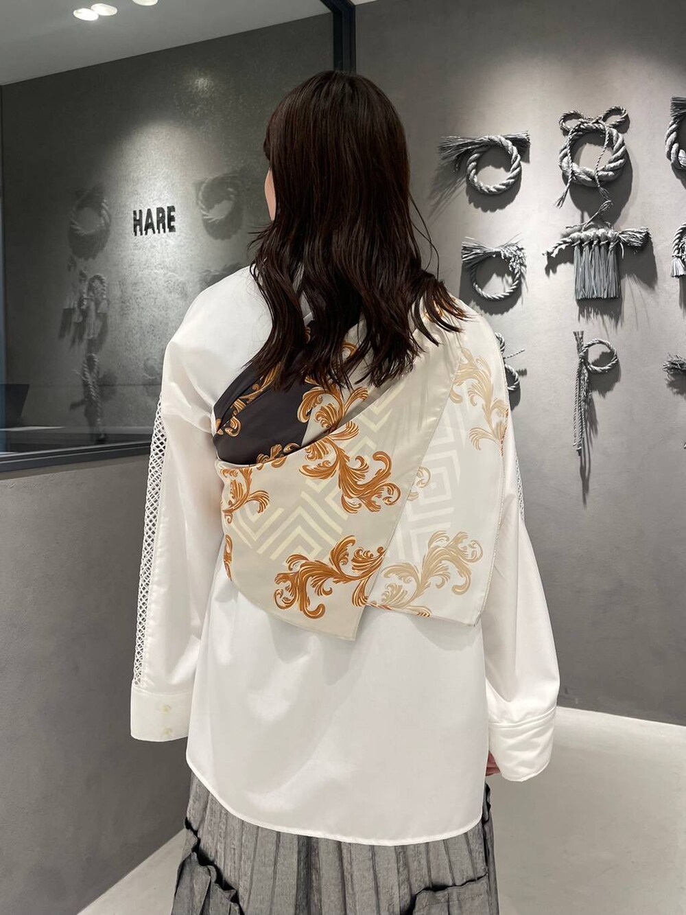 ブラック系のブーツ、ホワイト系のシャツ/ブラウス、シルバー系のスカートを着用したレディースの春コーディネートの5枚目の写真