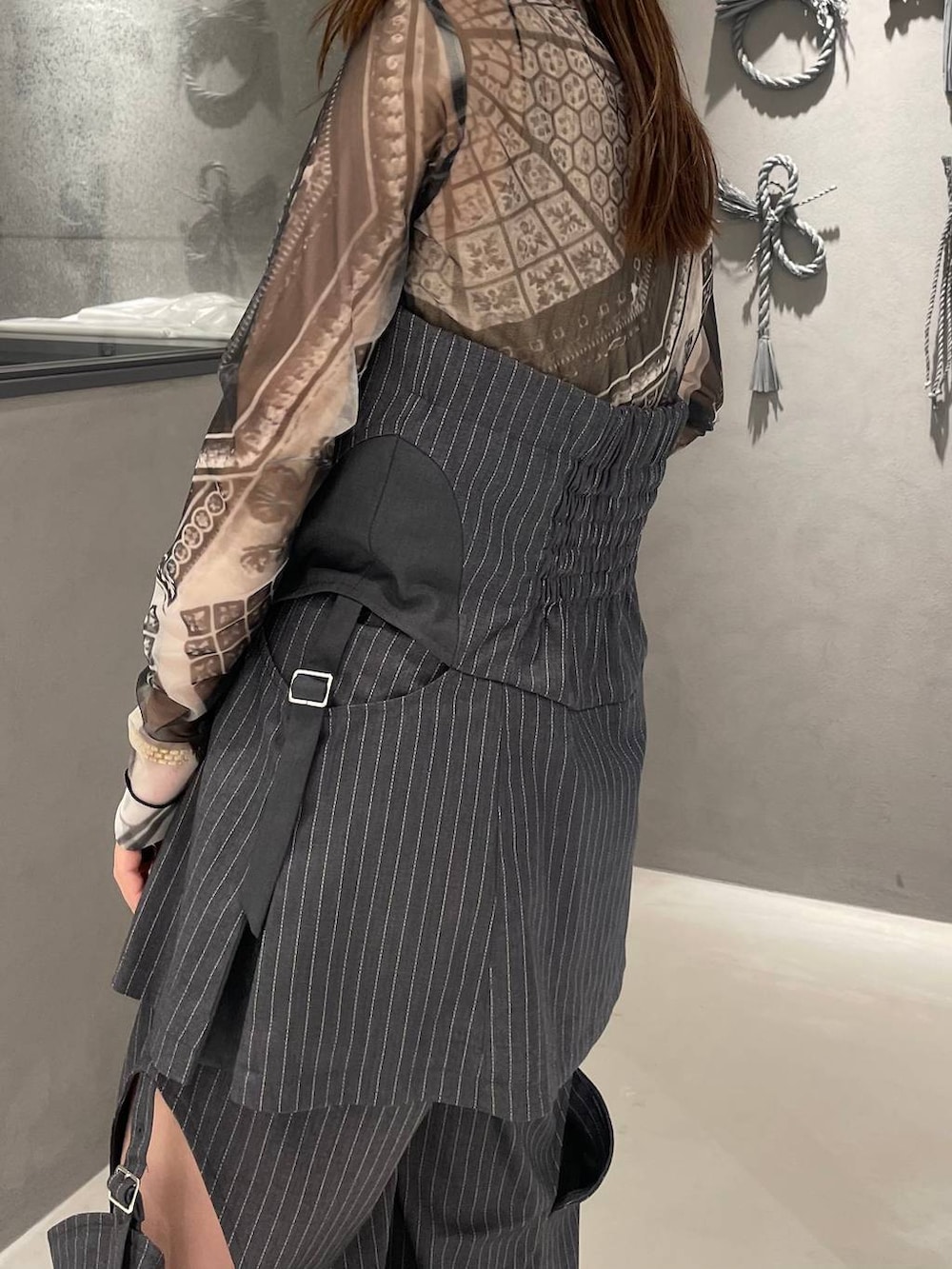 ブラック系のTシャツ/カットソー、ブラック系のサンダル、グレー系のベストを着用したレディースの春コーディネートの5枚目の写真