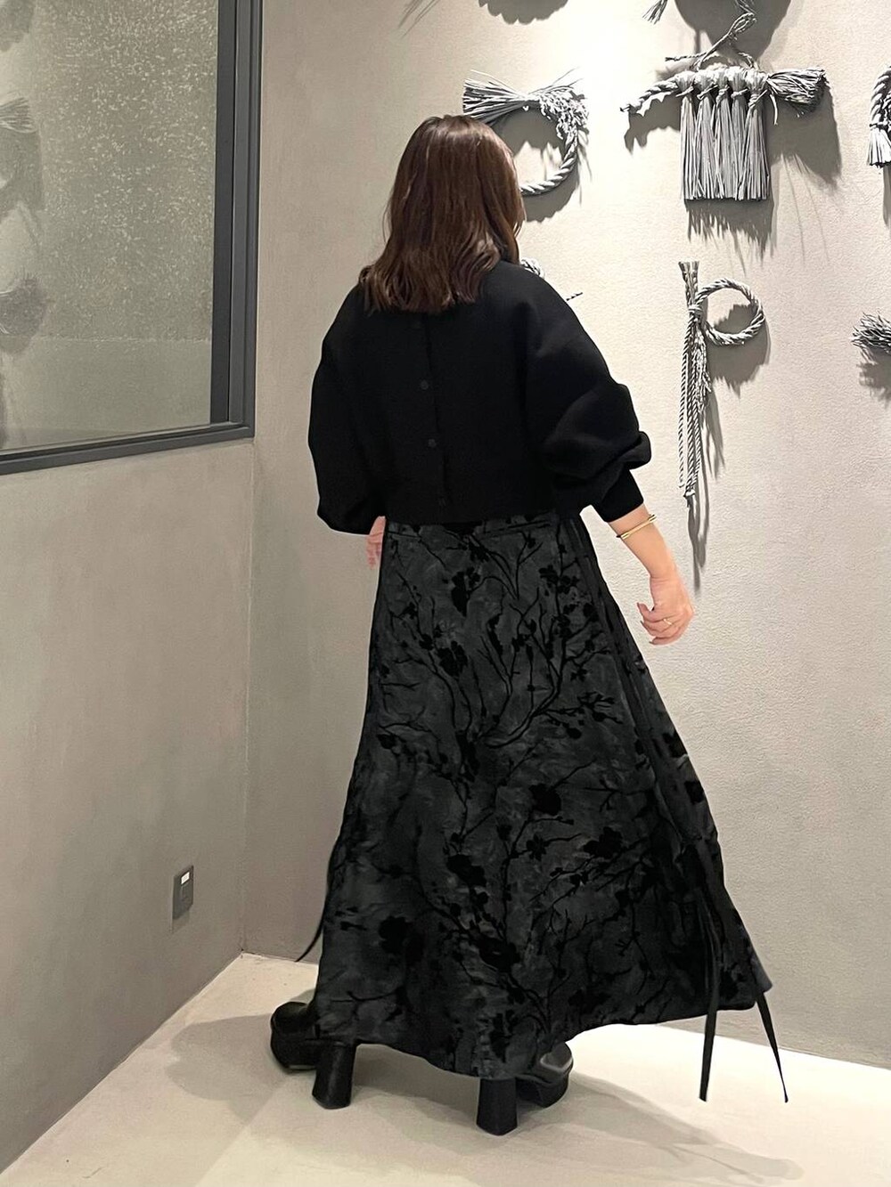 ブラック系のブーツ、ブラック系のニット/セーター、ブラック系のスカートを着用したレディースの冬コーディネートの3枚目の写真