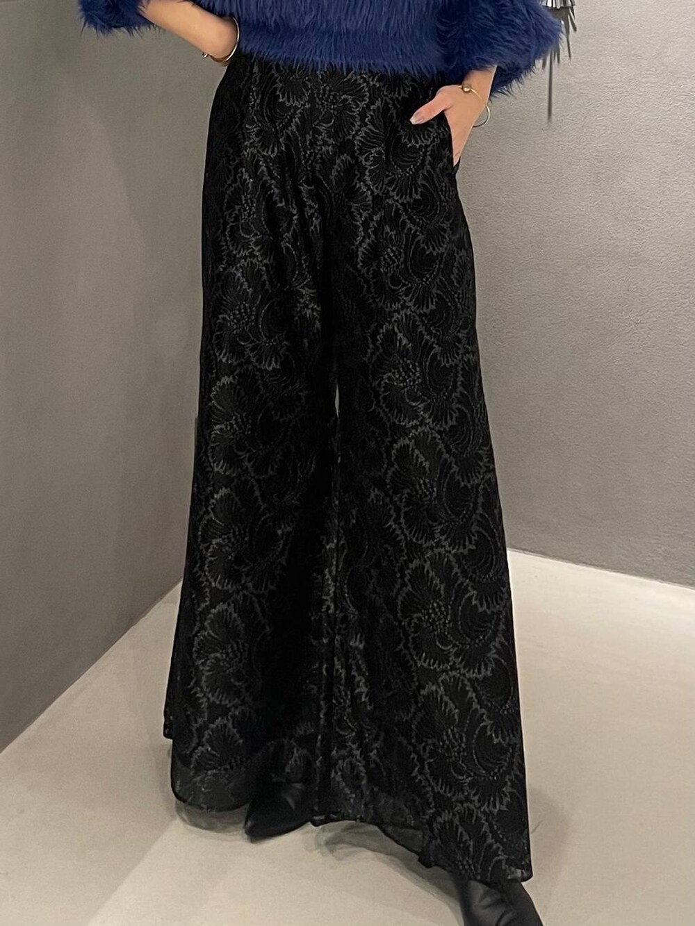 ブルー系のニット/セーター、ブラック系のブーツ、ブラック系のその他パンツを着用したレディースの秋コーディネートの5枚目の写真