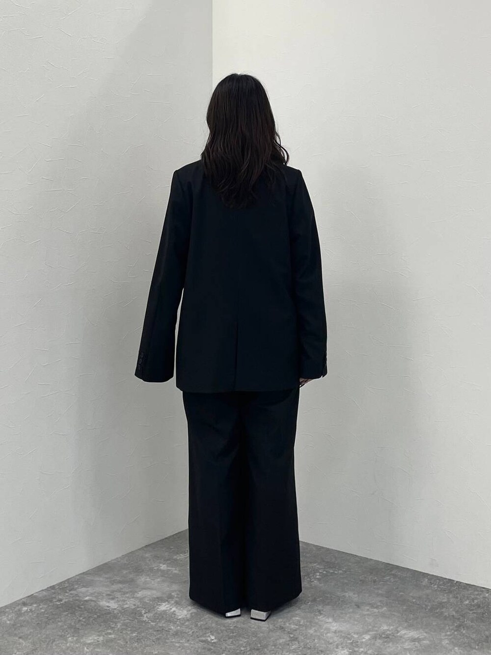 ブラック系のブーツ、ブラック系のノーカラージャケット、ブラック系のスラックスを着用したレディースの秋コーディネートの4枚目の写真