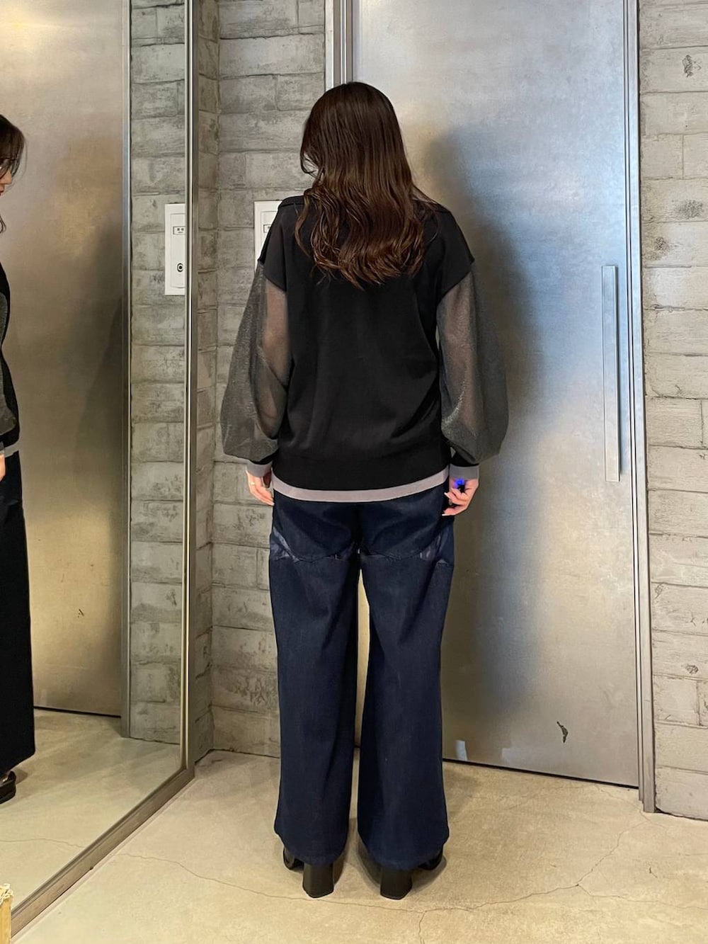 シルバー系のブーツ、ブルー系のデニムパンツ、ブラック系のカーディガン/ボレロを着用したレディースの春コーディネートの3枚目の写真