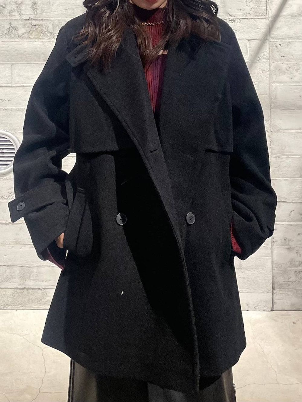 ブラック系のトレンチコート、ブラック系のブーツ、レッド系のニット/セーターを着用したレディースの秋コーディネートの5枚目の写真