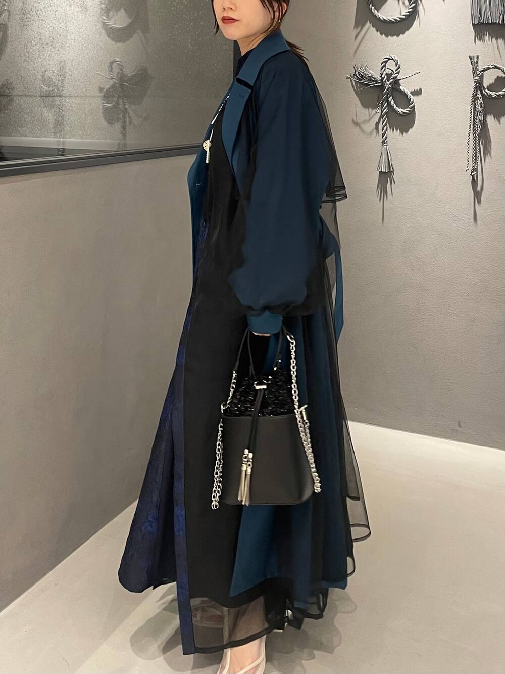 ホワイト系のサンダル、ブルー系のドレス、ブルー系のトレンチコートを着用したレディースの秋コーディネートの5枚目の写真