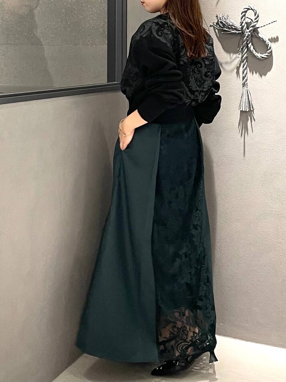 ブラック系のパンプス、グリーン系のスカート、グリーン系のスウェットを着用したレディースの夏コーディネートの3枚目の写真