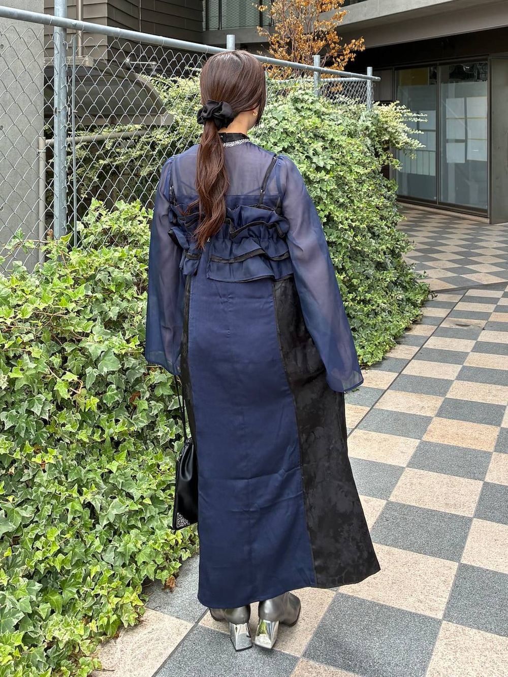 ブルー系のワンピース、ブラック系のトートバッグ、シルバー系のネックレスを着用したレディースの夏コーディネートの4枚目の写真
