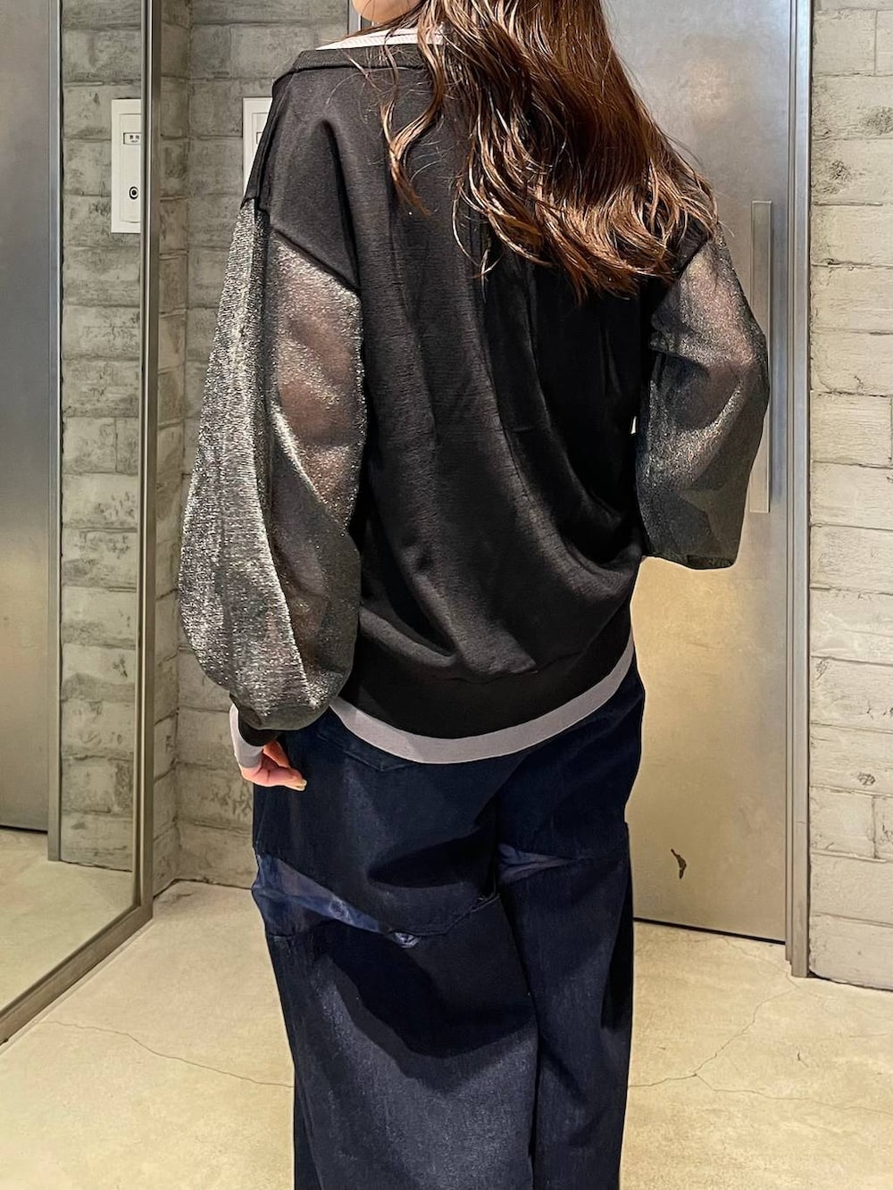 シルバー系のブーツ、ブルー系のデニムパンツ、ブラック系のカーディガン/ボレロを着用したレディースの春コーディネートの5枚目の写真