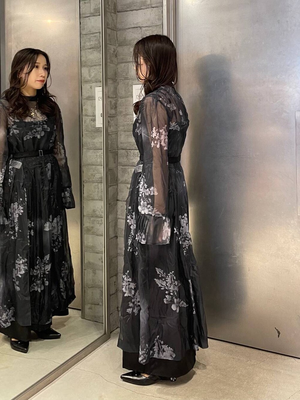 ブラック系のパンプス、ブラック系のワンピース、ゴールド系のネックレスを着用したレディースの冬コーディネートの3枚目の写真