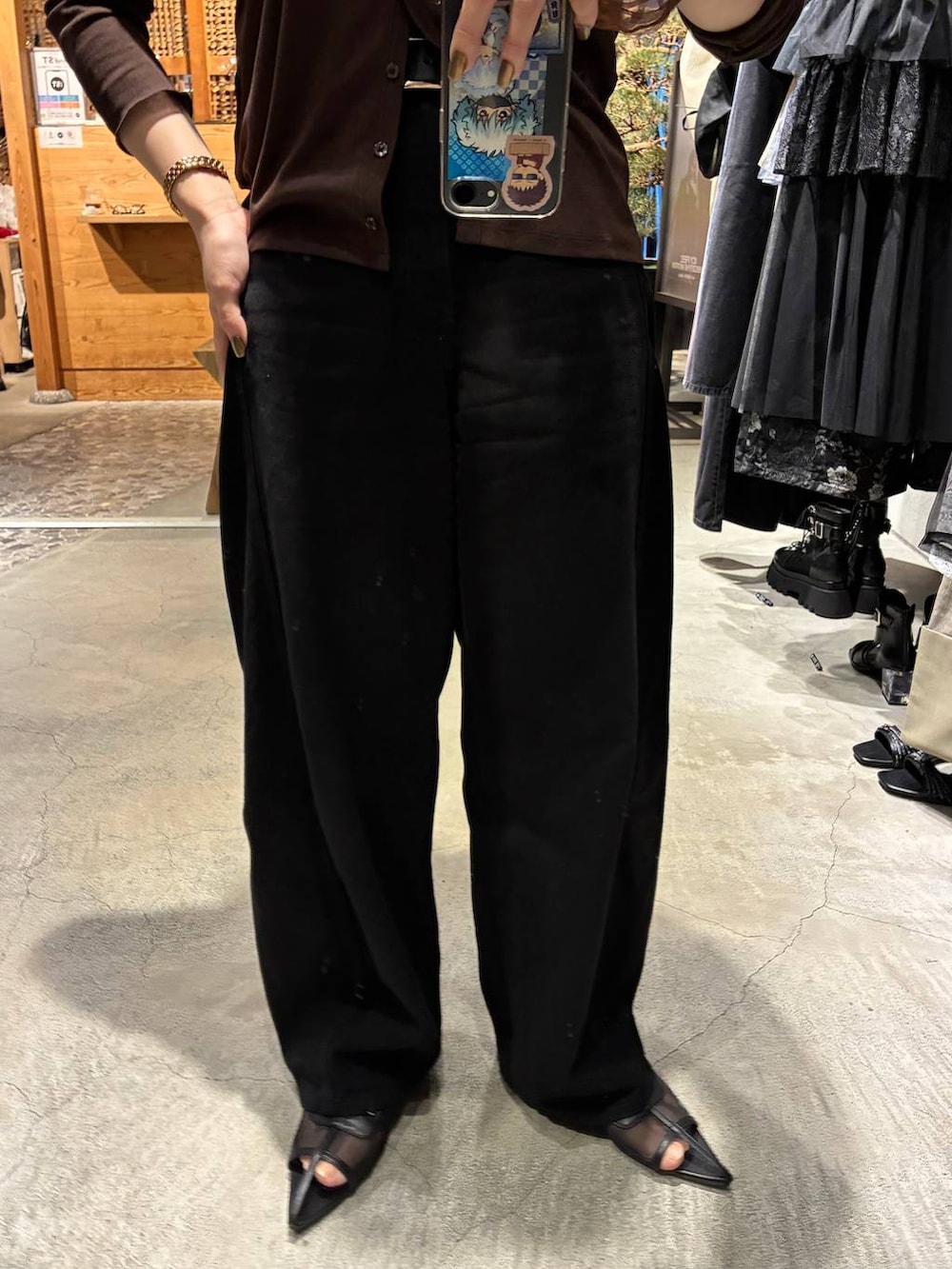ブラック系のデニムパンツ、ブラック系のサンダルを着用したレディースの春コーディネートの4枚目の写真