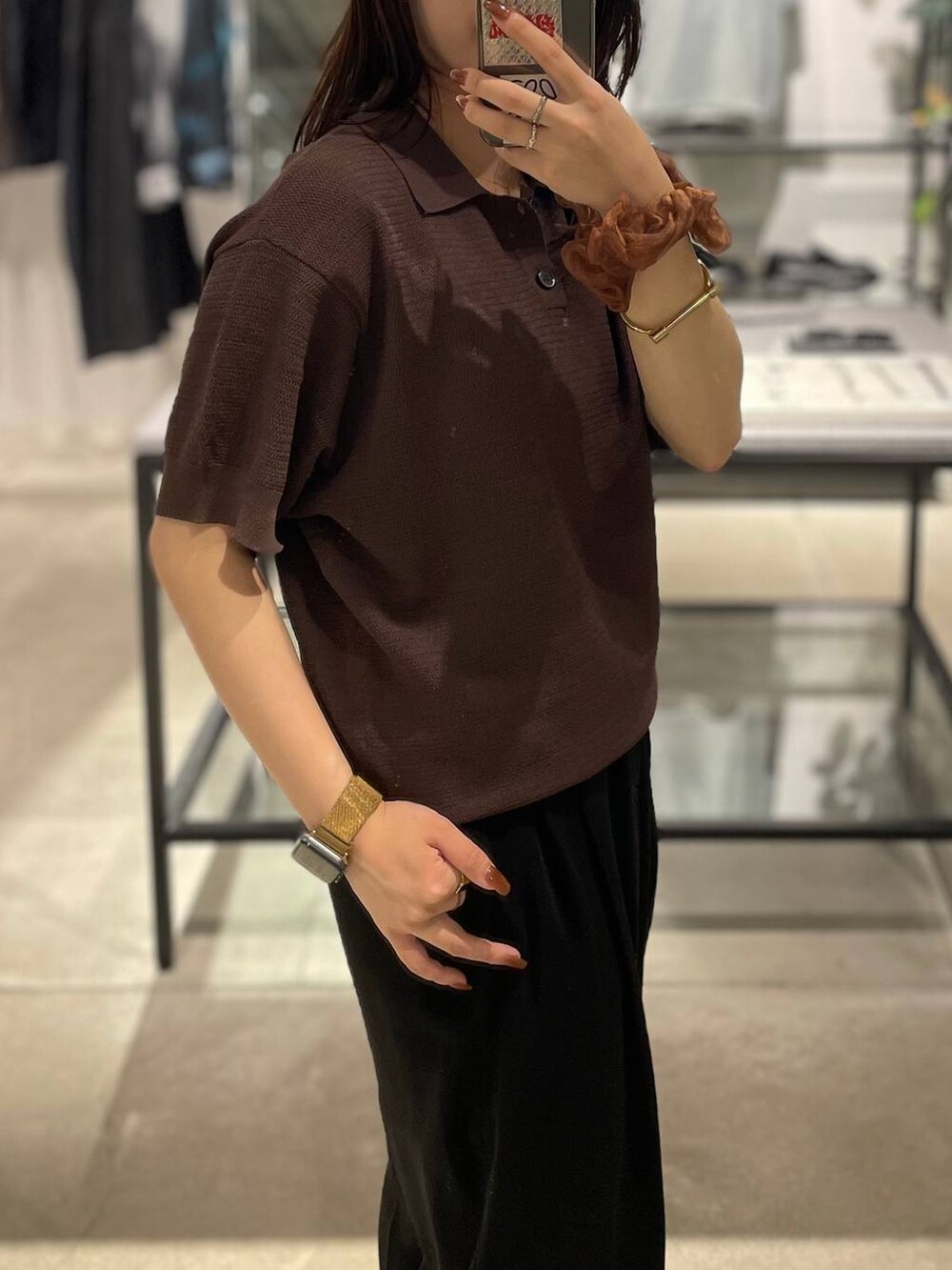 ブラウン系のポロシャツを着用したレディースの夏コーディネートの3枚目の写真