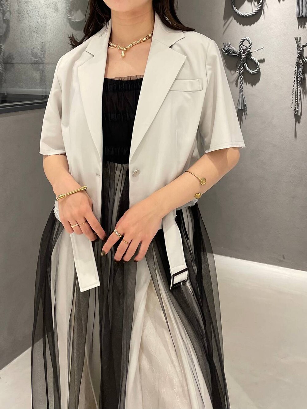 ブラック系のブーツ、ブラック系のタンクトップ、ブラック系のスカートを着用したレディースの夏コーディネートの3枚目の写真