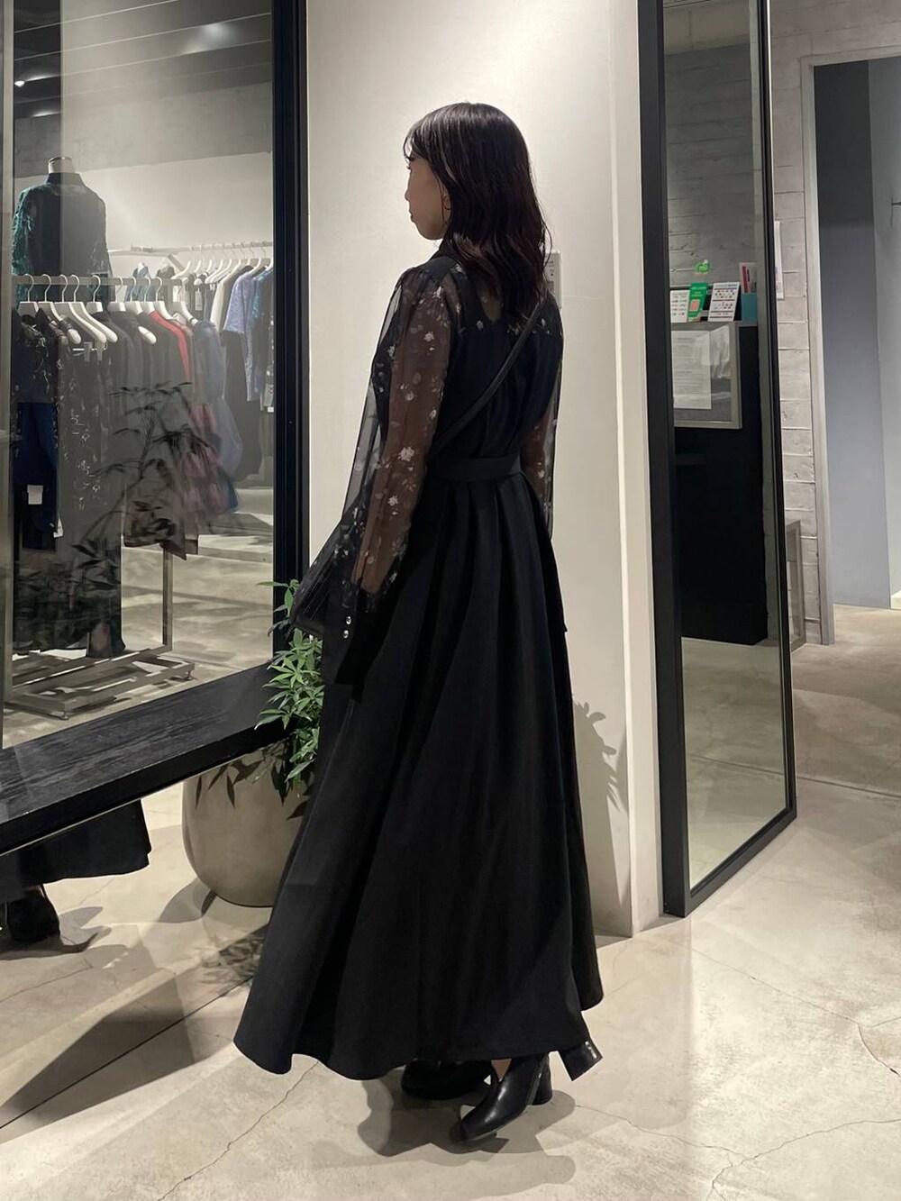 ブラック系のショルダーバッグ、ブラック系のパンプス、ブラック系のワンピースを着用したレディースの夏コーディネートの2枚目の写真