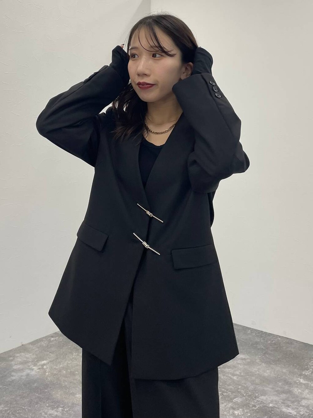 ブラック系のブーツ、ブラック系のノーカラージャケット、ブラック系のスラックスを着用したレディースの秋コーディネートの5枚目の写真