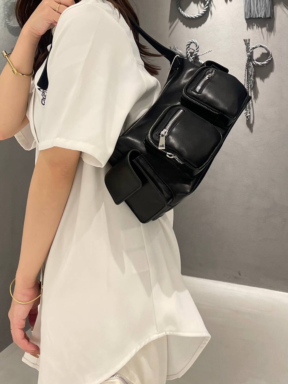 ブラック系のサンダル、ホワイト系のシャツ/ブラウス、ブラック系のショルダーバッグを着用したレディースの夏コーディネートの5枚目の写真