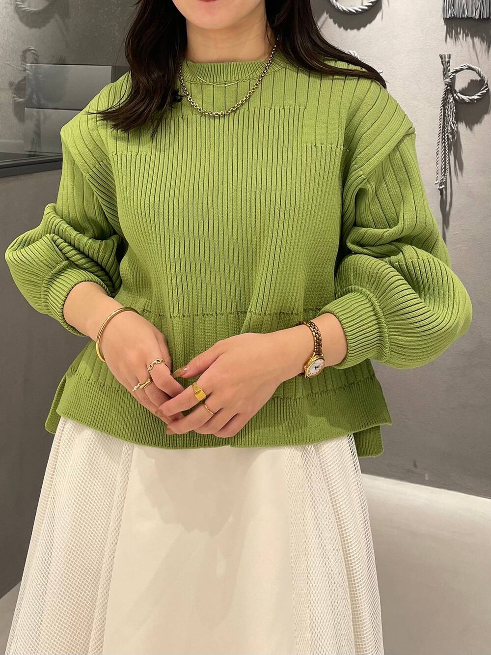 ブラック系のブーツ、イエロー系のニット/セーター、ホワイト系のスカートを着用したレディースの冬コーディネートの4枚目の写真