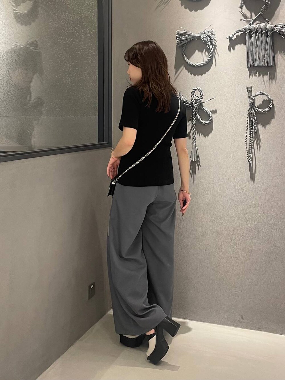 ホワイト系のサンダル、グレー系のその他パンツ、ブラック系のTシャツ/カットソーを着用したレディースの春コーディネートの2枚目の写真