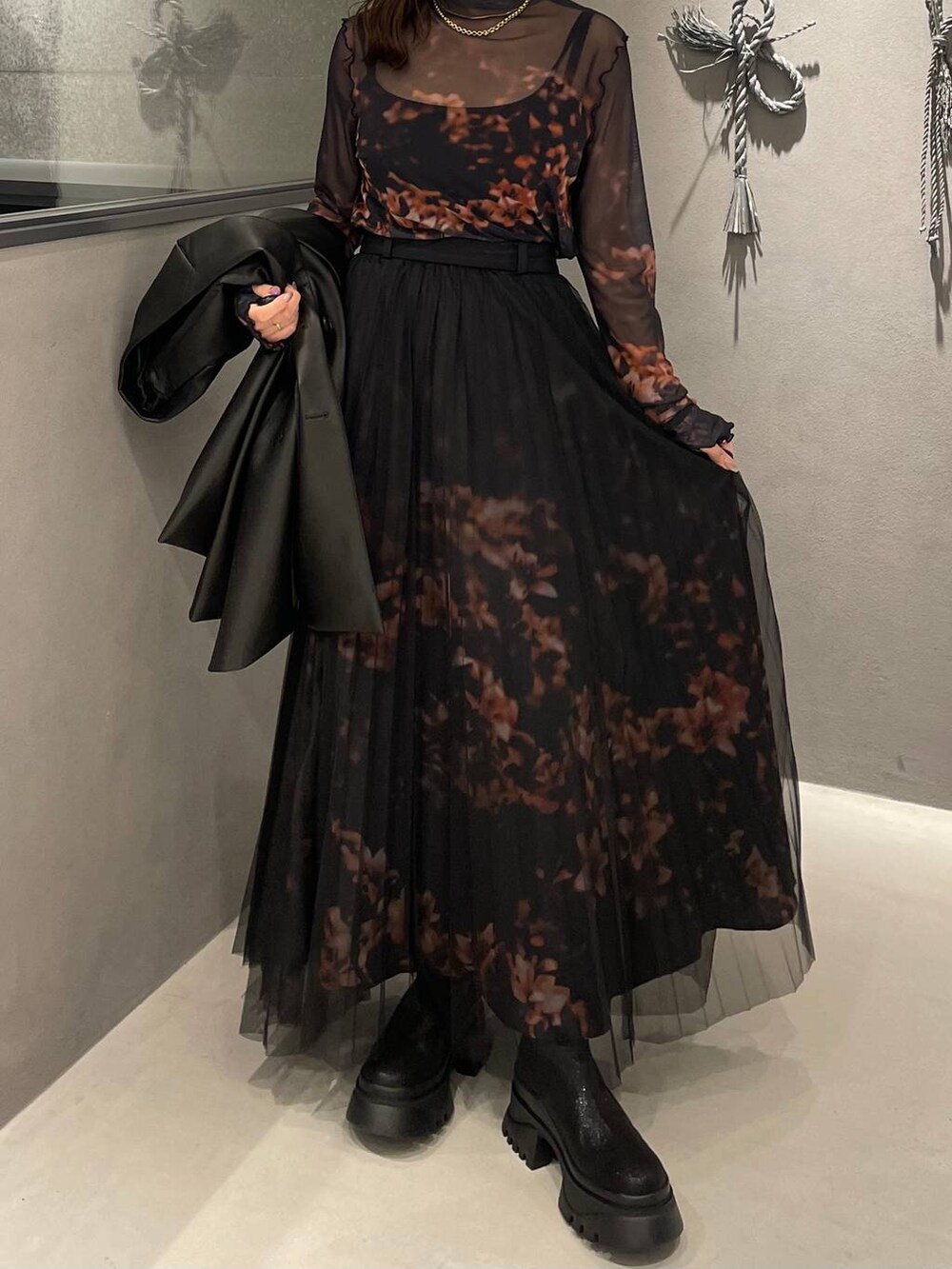 ブラック系のブーツ、オレンジ系のスカート、オレンジ系のTシャツ/カットソーを着用したレディースの秋コーディネートの4枚目の写真