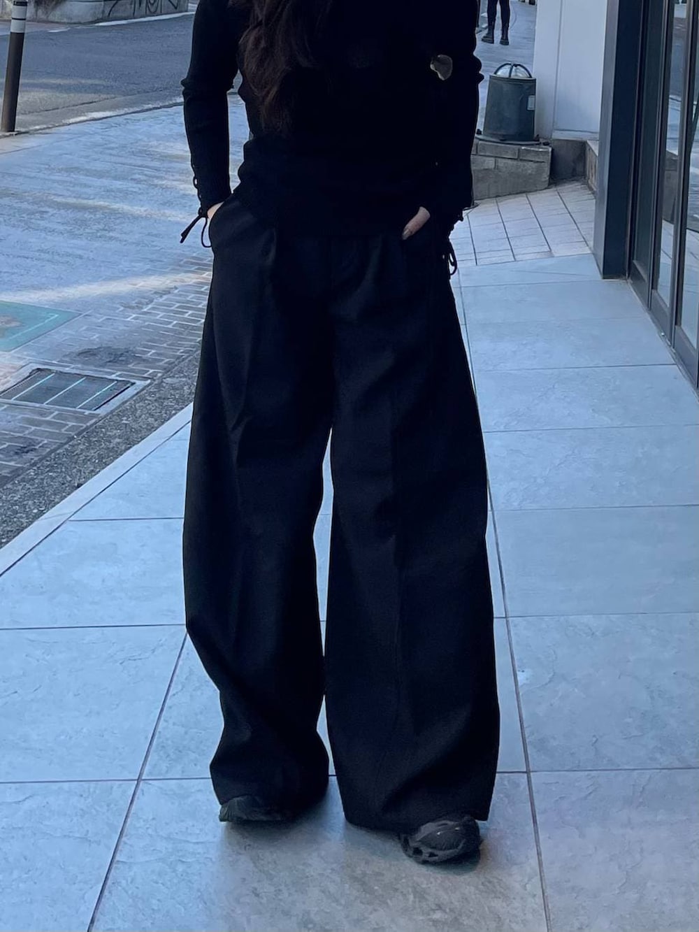 ブラック系のスラックス、ブラック系のニット/セーターを着用したレディースの冬コーディネートの2枚目の写真