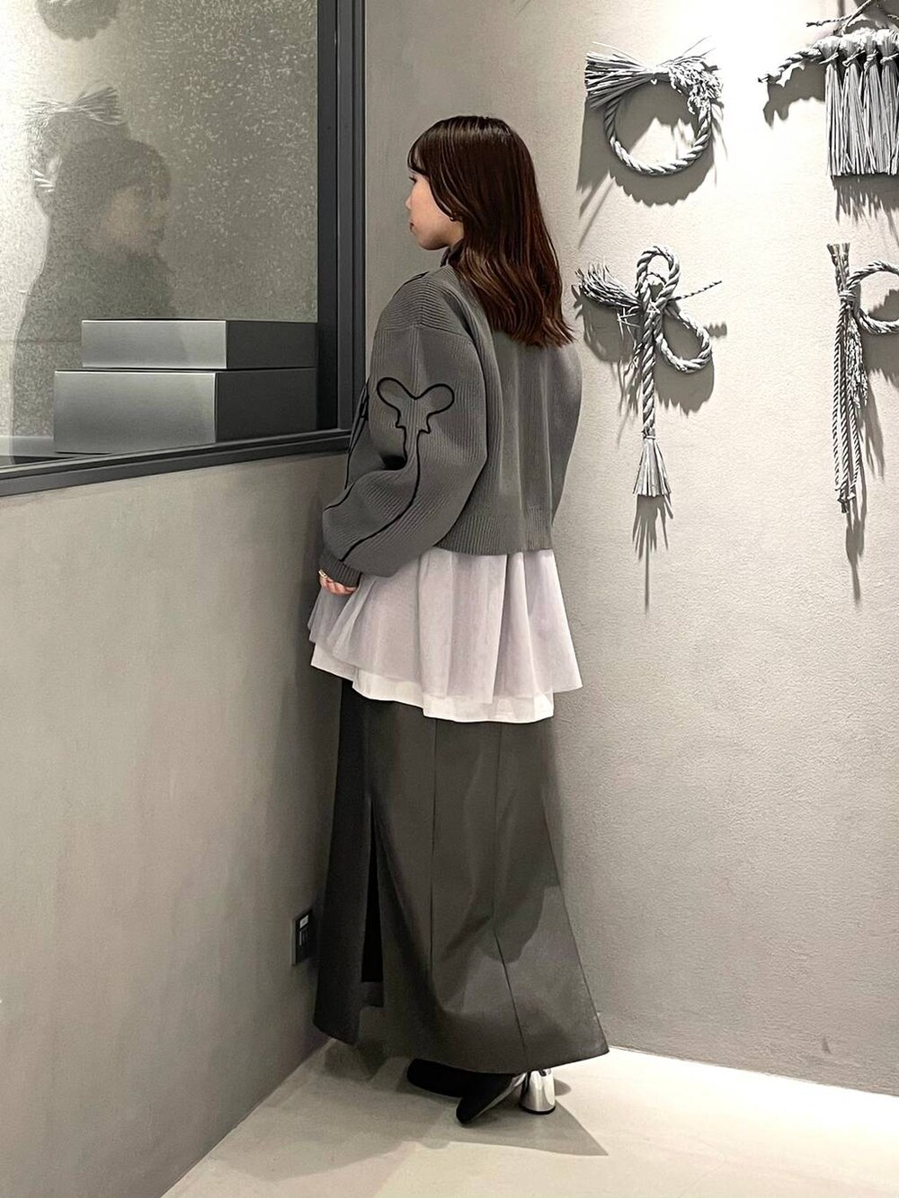 ブラック系のブーツ、グレー系のシャツ/ブラウス、グレー系のニット/セーターを着用したレディースの冬コーディネートの2枚目の写真