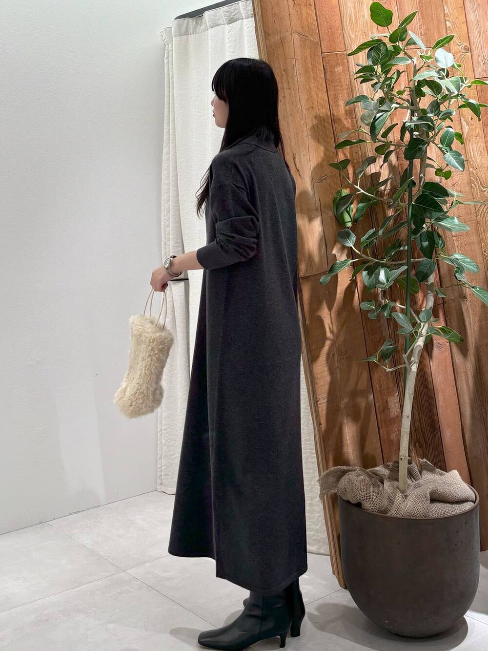 ホワイト系のハンドバッグ、グレー系のワンピースを着用したレディースの秋コーディネートの3枚目の写真