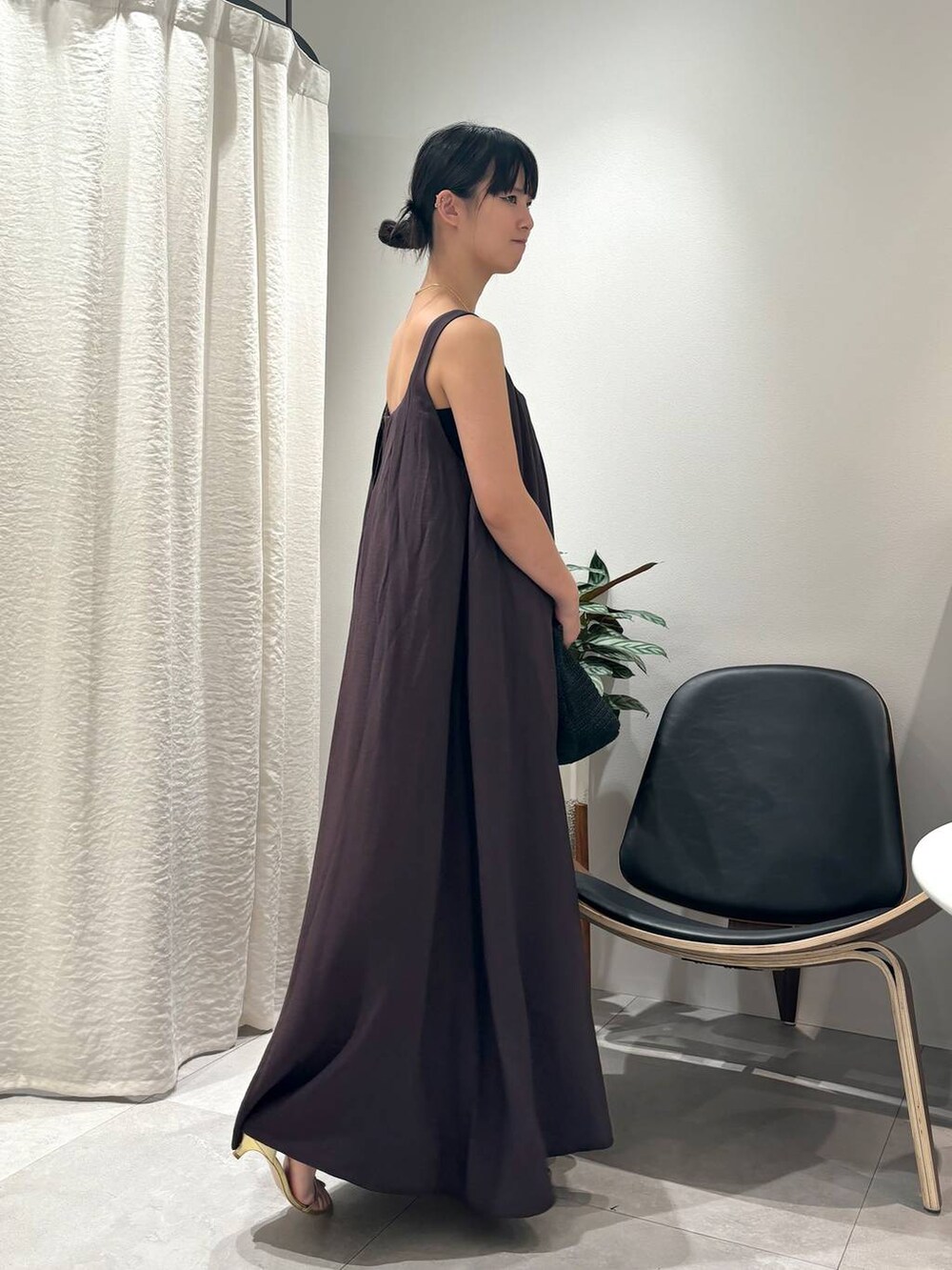 ブラウン系のワンピース、ゴールド系のサンダル、ゴールド系のブレスレットを着用したレディースの春コーディネートの2枚目の写真