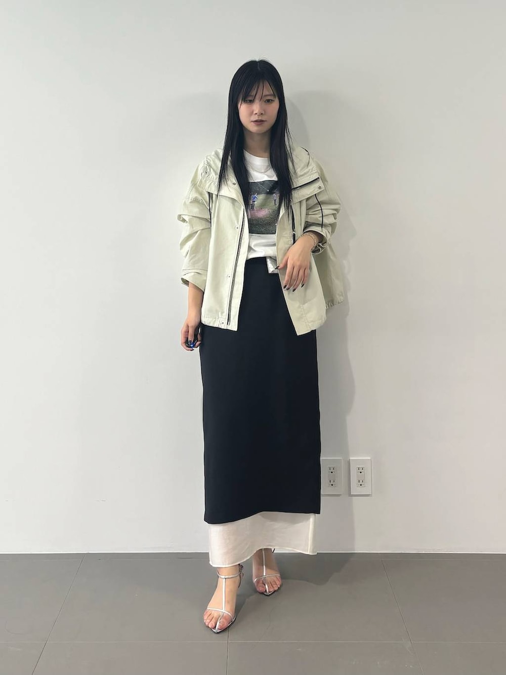 ホワイト系のマウンテンパーカー、ブラック系のスカート、ホワイト系のTシャツ/カットソーを着用したレディースの春コーディネートの5枚目の写真