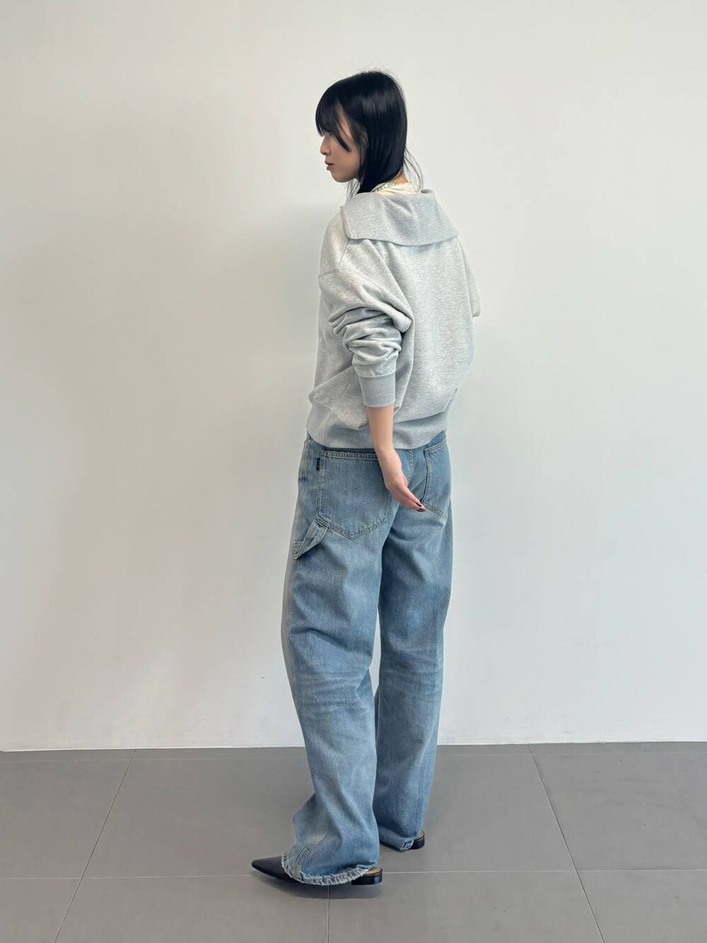 グレー系のスウェット、ホワイト系のTシャツ/カットソー、ブルー系のデニムパンツを着用したレディースの冬コーディネートの2枚目の写真