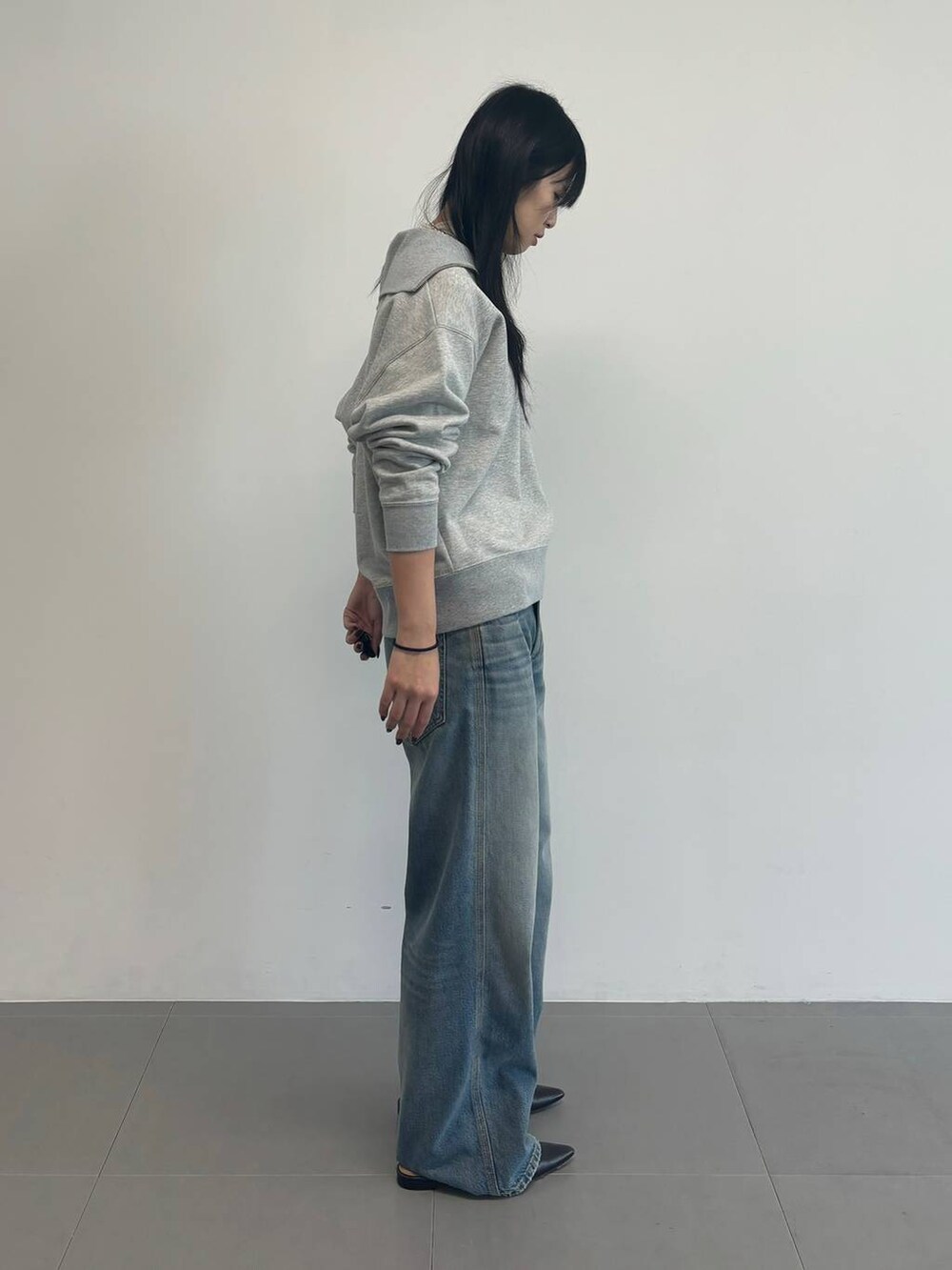 グレー系のスウェット、ホワイト系のTシャツ/カットソー、ブルー系のデニムパンツを着用したレディースの冬コーディネートの3枚目の写真