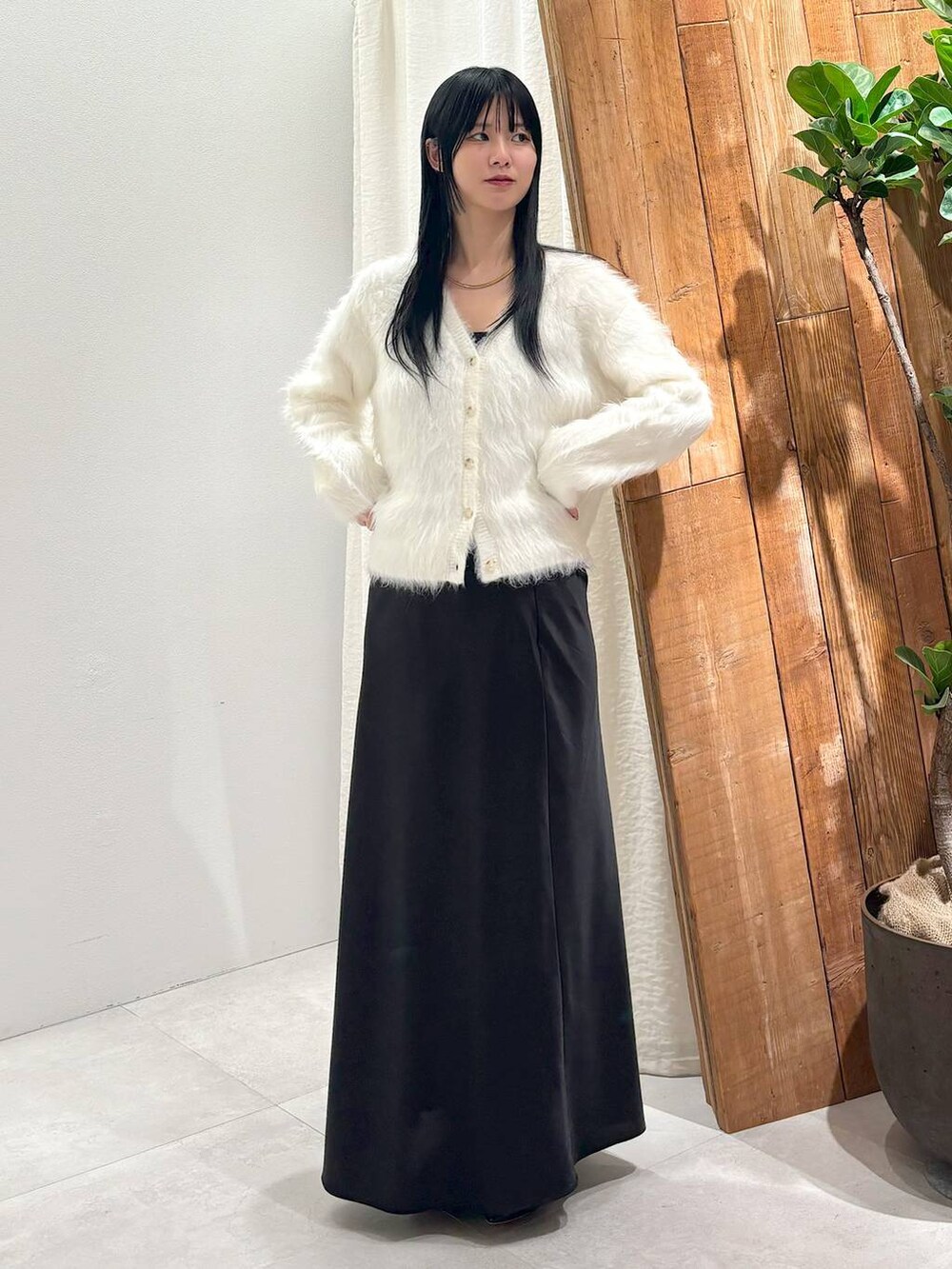 ブラック系のスカート、ホワイト系のカーディガン/ボレロを着用したレディースの秋コーディネートの4枚目の写真