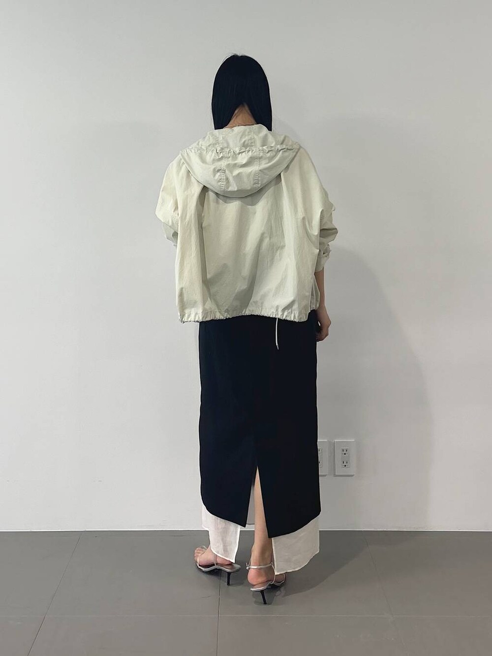 ホワイト系のマウンテンパーカー、ブラック系のスカート、ホワイト系のTシャツ/カットソーを着用したレディースの春コーディネートの4枚目の写真