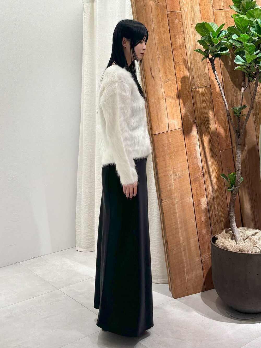 ブラック系のスカート、ホワイト系のカーディガン/ボレロを着用したレディースの秋コーディネートの2枚目の写真