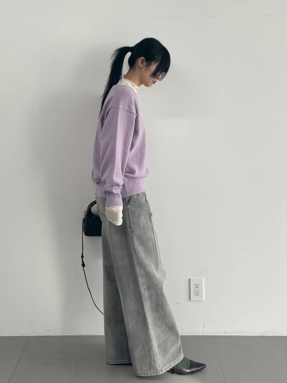 ホワイト系のTシャツ/カットソー、グレー系のデニムパンツ、パープル系のニット/セーターを着用したレディースの冬コーディネートの2枚目の写真