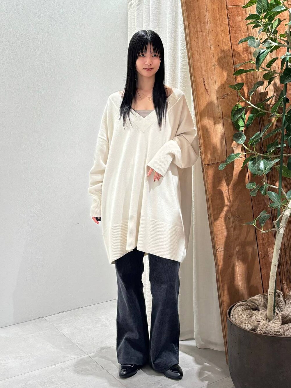 ホワイト系のニット/セーター、グレー系のその他パンツを着用したレディースの秋コーディネートの4枚目の写真