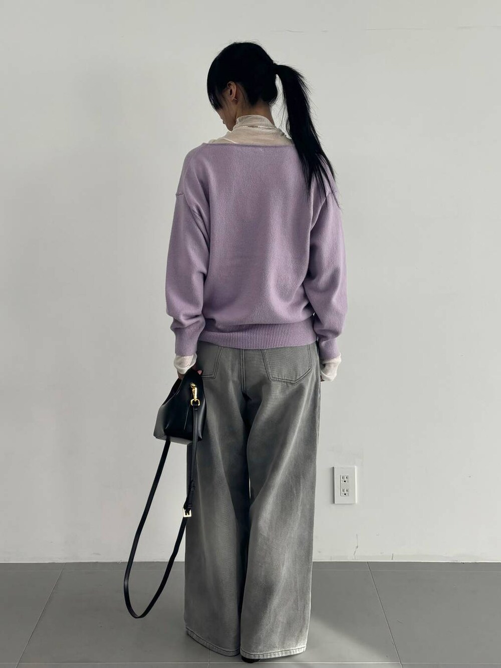 ホワイト系のTシャツ/カットソー、グレー系のデニムパンツ、パープル系のニット/セーターを着用したレディースの冬コーディネートの4枚目の写真