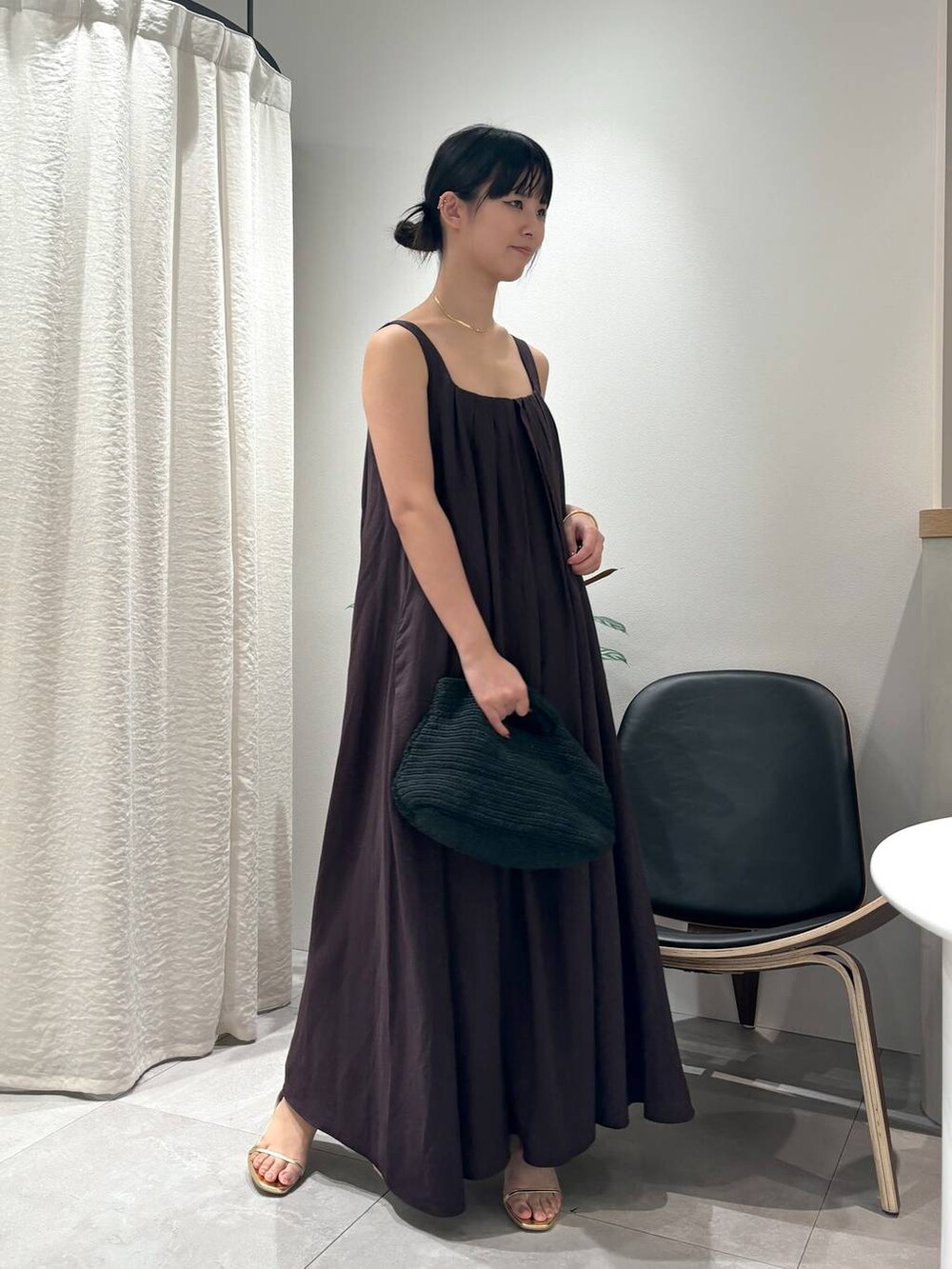 ブラウン系のワンピース、ゴールド系のサンダル、ゴールド系のブレスレットを着用したレディースの春コーディネートの6枚目の写真