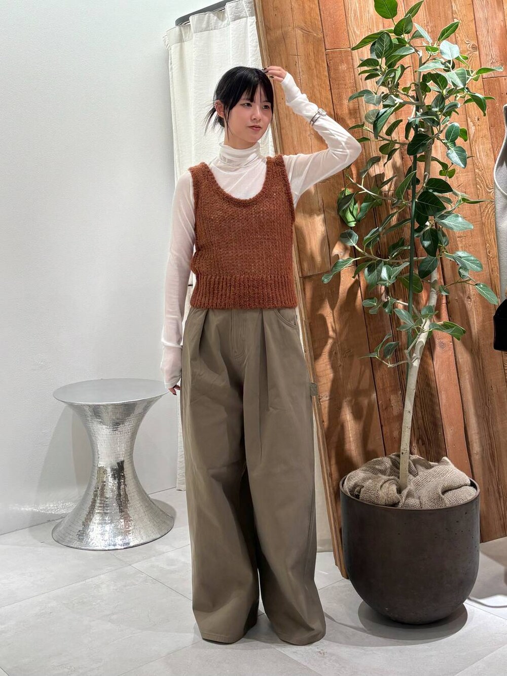 グリーン系のチノパンツ、ホワイト系のTシャツ/カットソー、ブラウン系のベストを着用したレディースの秋コーディネートの4枚目の写真