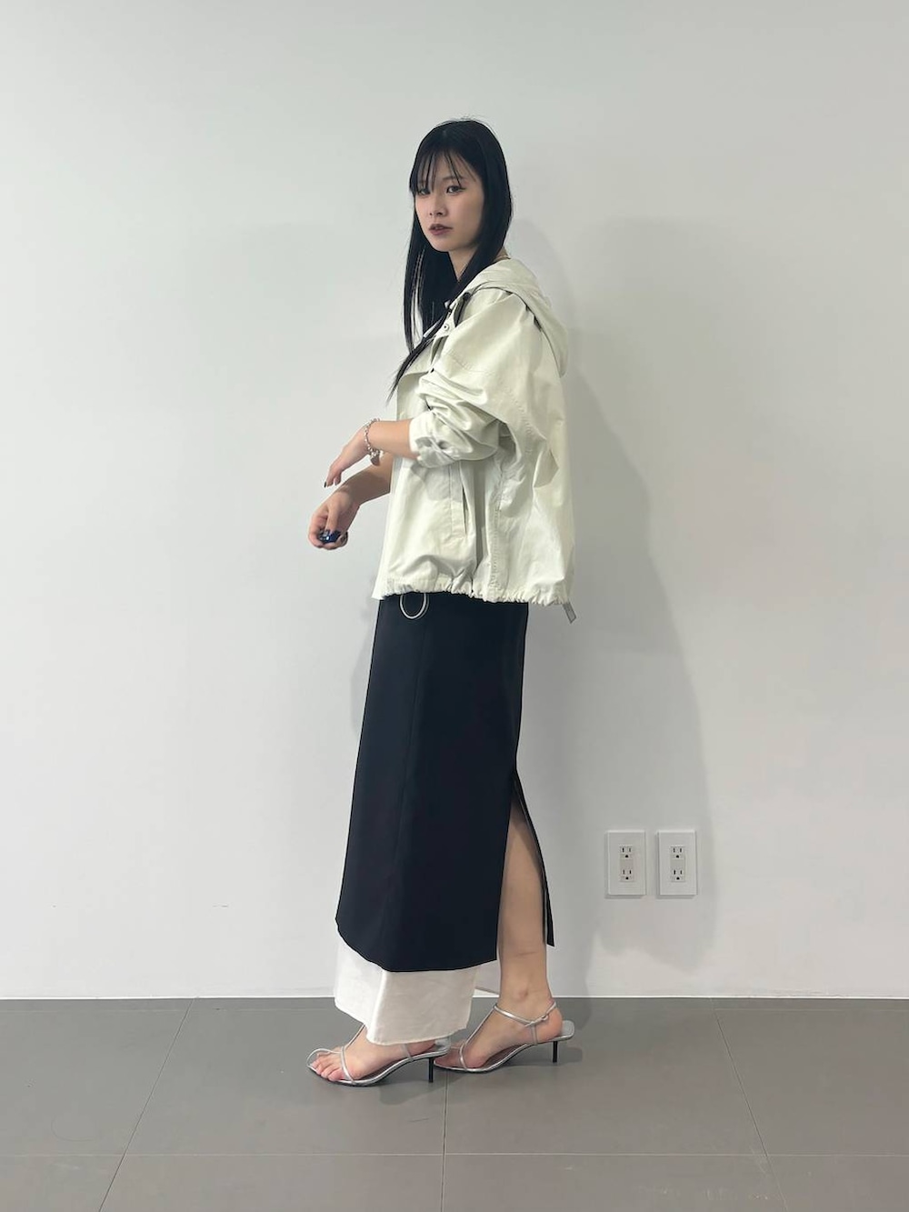 ホワイト系のマウンテンパーカー、ブラック系のスカート、ホワイト系のTシャツ/カットソーを着用したレディースの春コーディネートの3枚目の写真